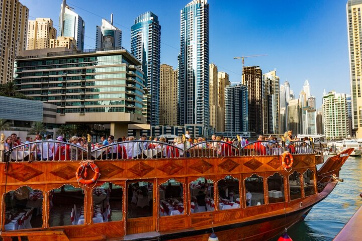 Glide through Dubai Marina on a charming Dhow surrounded by stunning skyscrapers and enjoy a delightful dinner as the city transforms under the night sky.